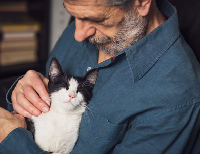 older man with black and white cat