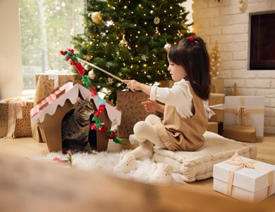 petite fille joue avec chat dans décor de Noel