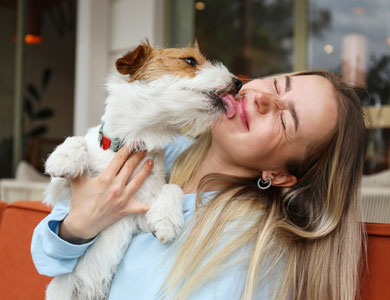 dog licking the face of a blonde woman